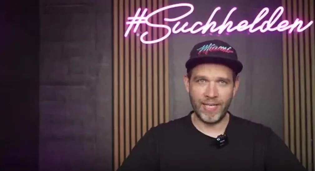 André Hehemann vor dem #Suchhelden-Neonschild