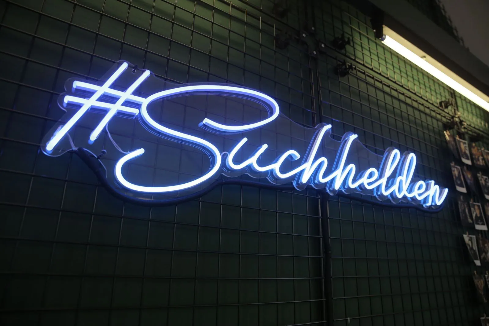 Neonschriftzug „#Suchhelden“ an der Fotowand im Suchhelden-Büro in Osnabrück